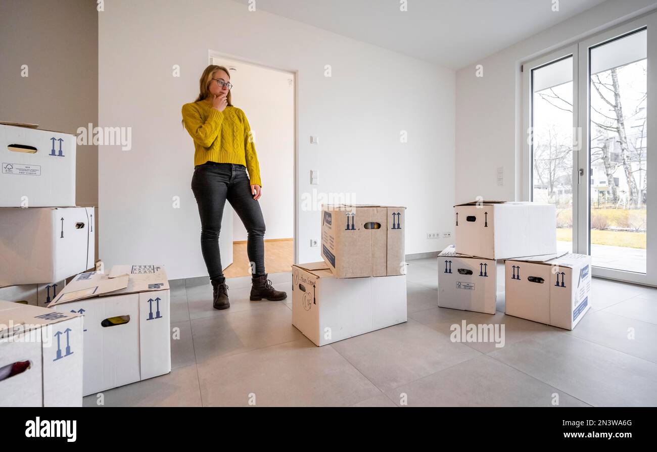 Die junge Frau zieht in eine leere Wohnung, in Deutschland Stockfoto