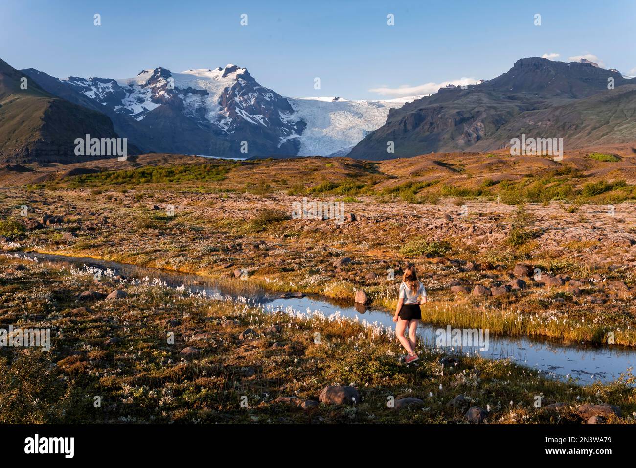 Junge Frau in der Natur, Reflexion in einem See, Blick auf Gletscherzungen und Berge, Gletscherzungen auf Vatnajoekull-Gletscher, Mount Kristinartindar Stockfoto
