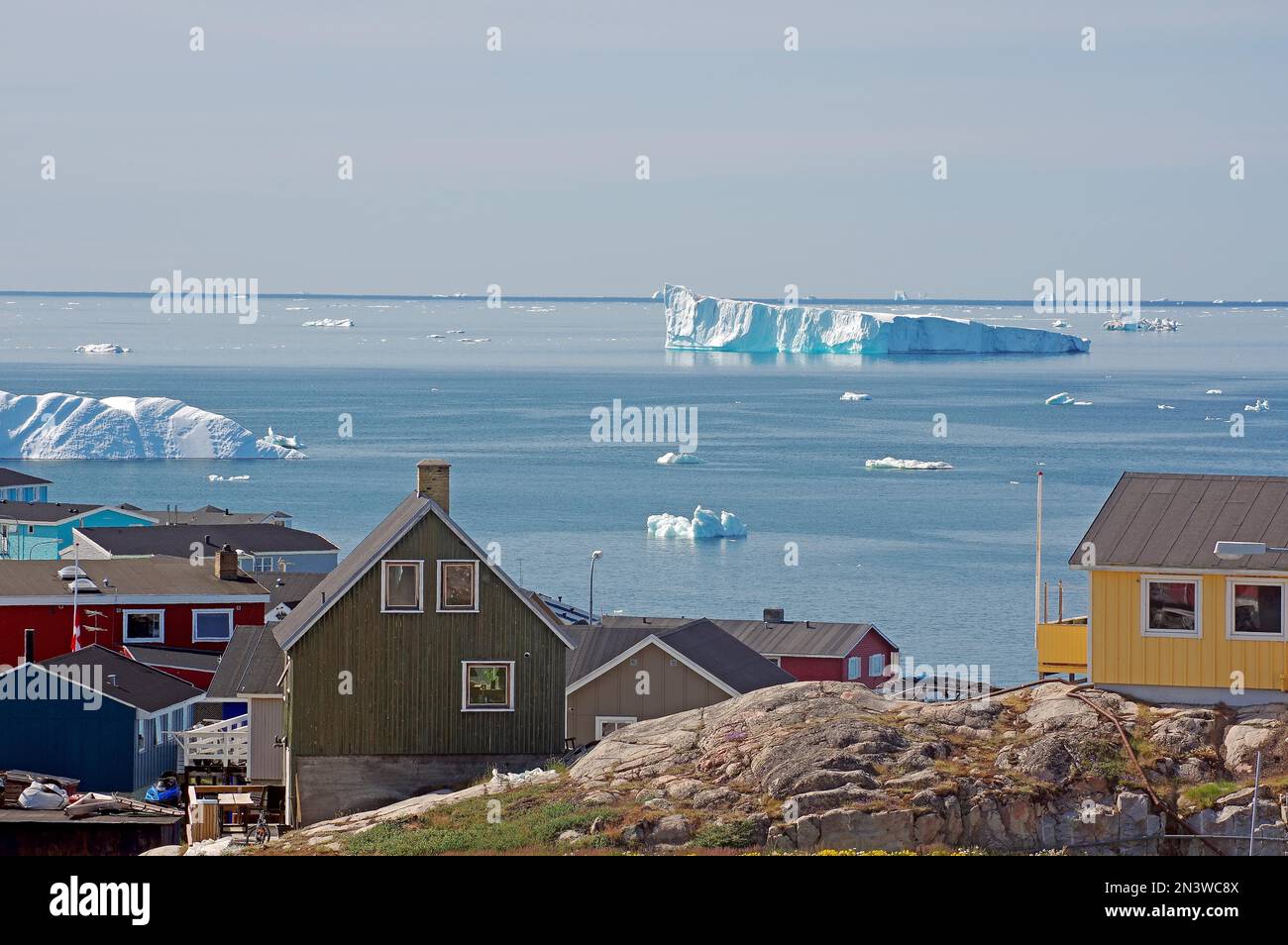 Einfache Wohnungen am Rande einer eisbergsbedeckten Bucht, Ilulissat, Arktis, Disko-Bucht, Grönland, Dänemark Stockfoto