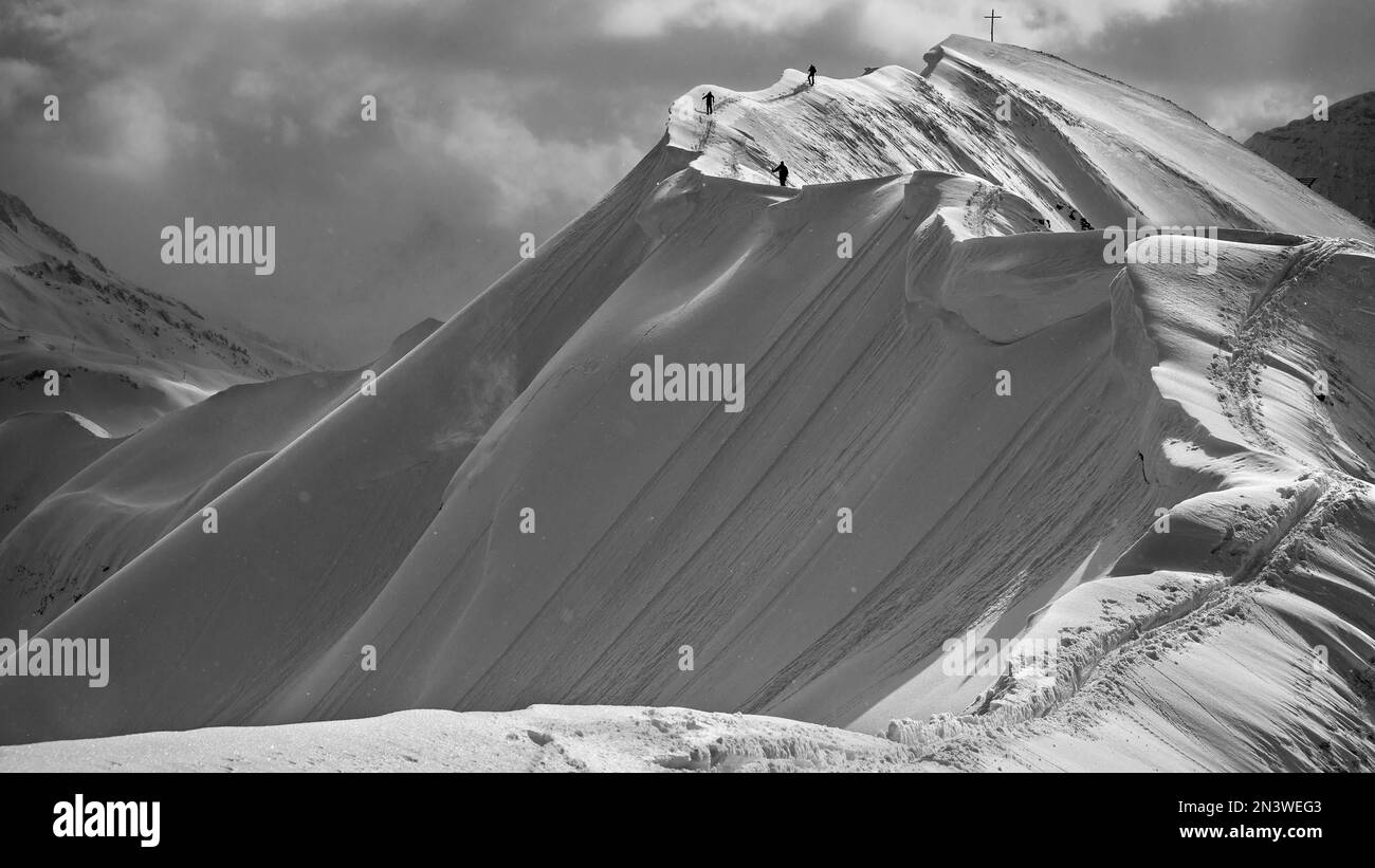 Gipfelkreuz der Hoeferspitze mit überdachtem Gipfelkamm und Bergsteigern, Baad, Kleinwalsertal, Vorarlberg, Österreich Stockfoto