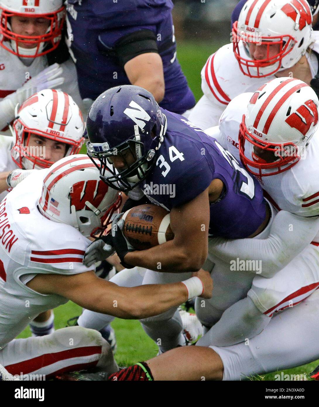 Northwestern running back Warren Long (34) is tackled by Wisconsin defenders during the first half of an NCAA college football game in Evanston, Ill., Saturday, Oct. 4, 2014. (AP Photo/Nam Y. Huh) Stockfoto