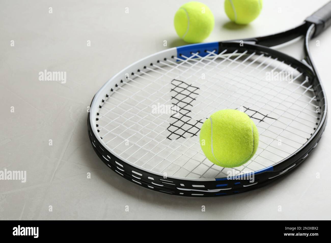 Tennisschläger und Bälle auf grauem Tisch. Sportausrüstung Stockfoto