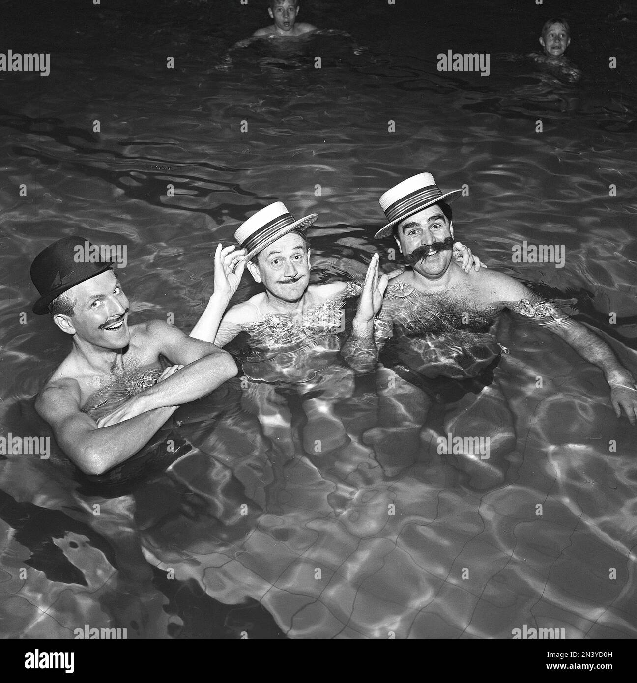 In den 1950er Jahren. Drei Männer im Wasser mit Hüten und falschen Schnurrbärten. Schweden 1955. Kristoffersson Ref. BT11-4 Stockfoto