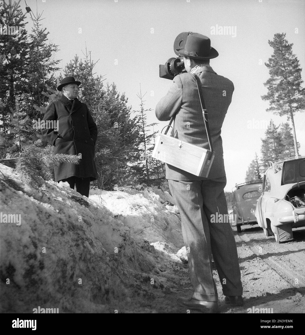 Filmen in den 1950er. Ein Filmfotograf mit seiner Kamera, der einen Mann filmt, der neben der Straße steht. Schweden 1956 Kristoffersson Ref BX48-12 Stockfoto