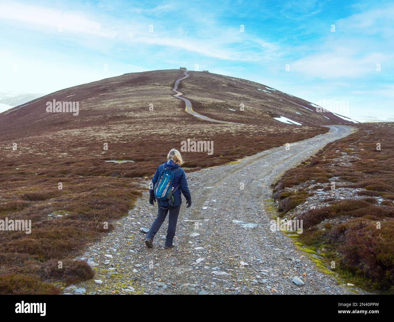 Ein Wanderer auf dem Weg zum Corbett-Berg Morrone oder Morven (aus der Ferne gesehen) in der Nähe von Braemar, Aberdeenshire Stockfoto