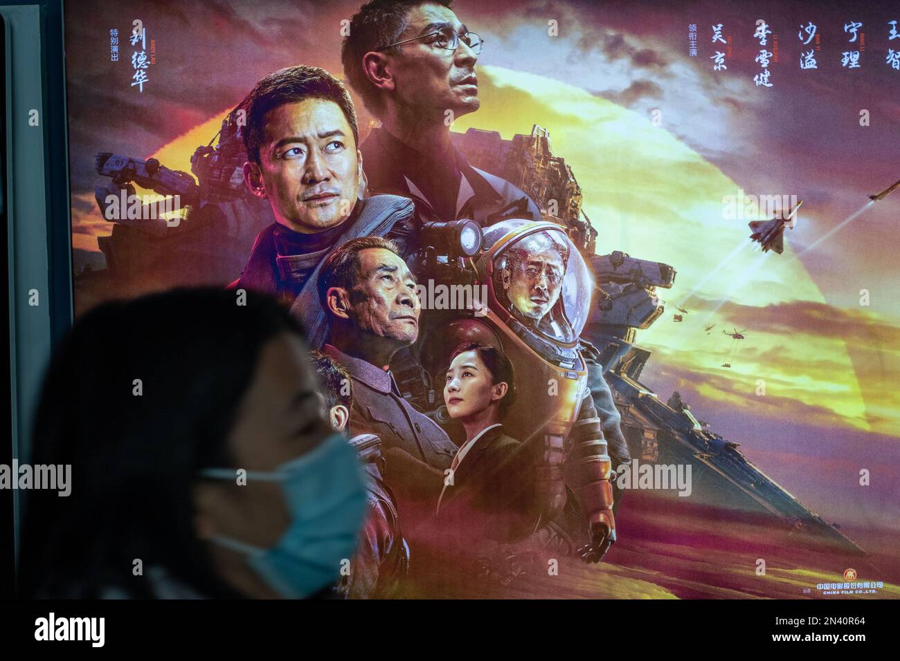 Lady vorbei an einem Poster des chinesischen Films „The Wandering Earth II“ in einem Kino in Peking, China. 08-Feb-2023 Stockfoto