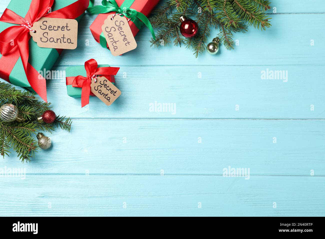Flach liegend mit Geschenken vom geheimen Weihnachtsmann auf türkisfarbenem Holztisch, Platz für Text Stockfoto