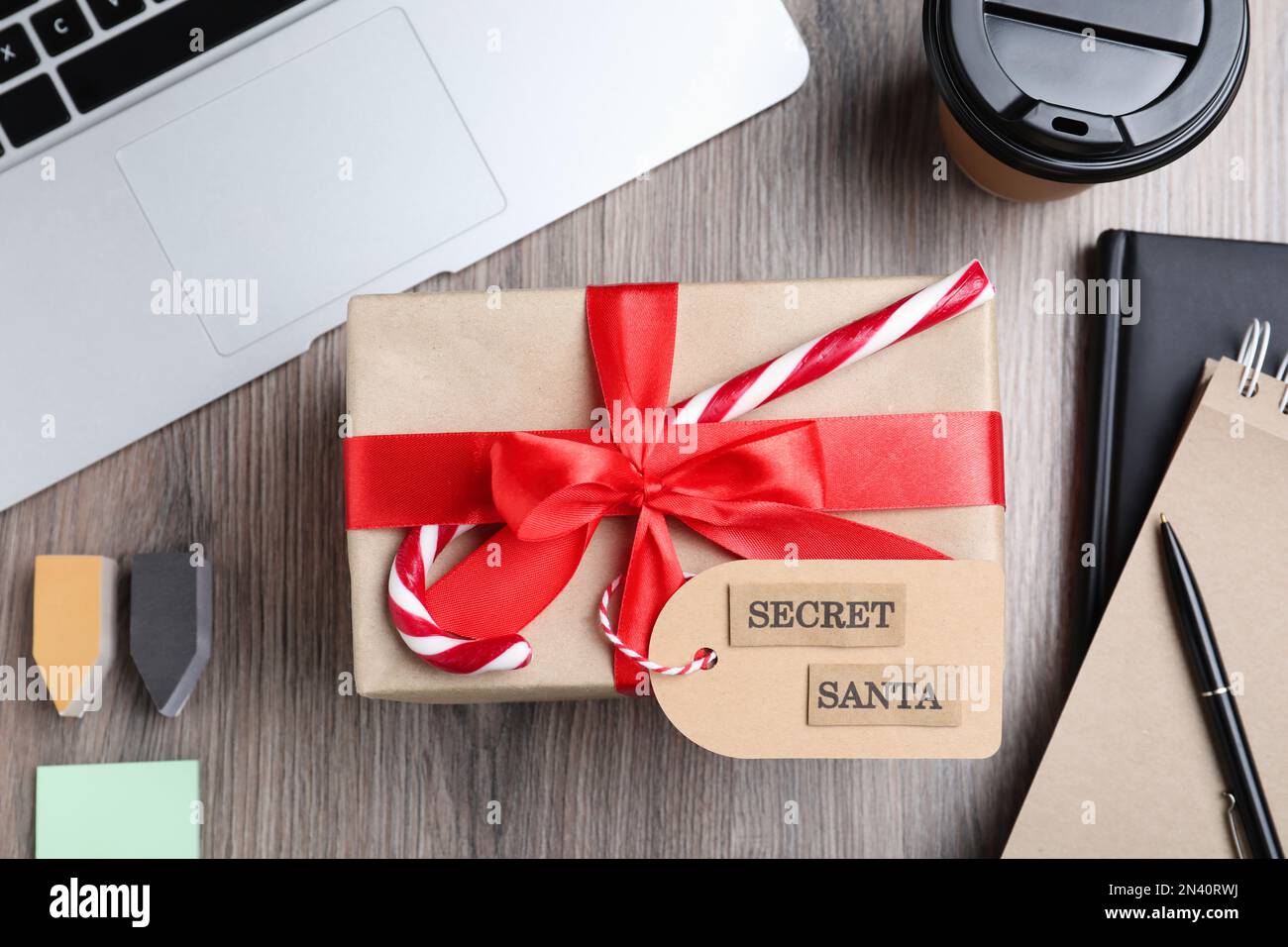 Geschenk vom geheimen Weihnachtsmann auf einem Holztisch im Büro, flach liegend Stockfoto