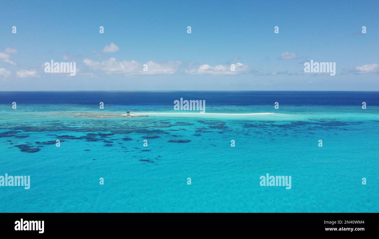 Luftaufnahme einer kleinen sandkai mit einer abgelegenen Wetterstation umgeben von einem Riff im Korallenmeer vor Australien Stockfoto