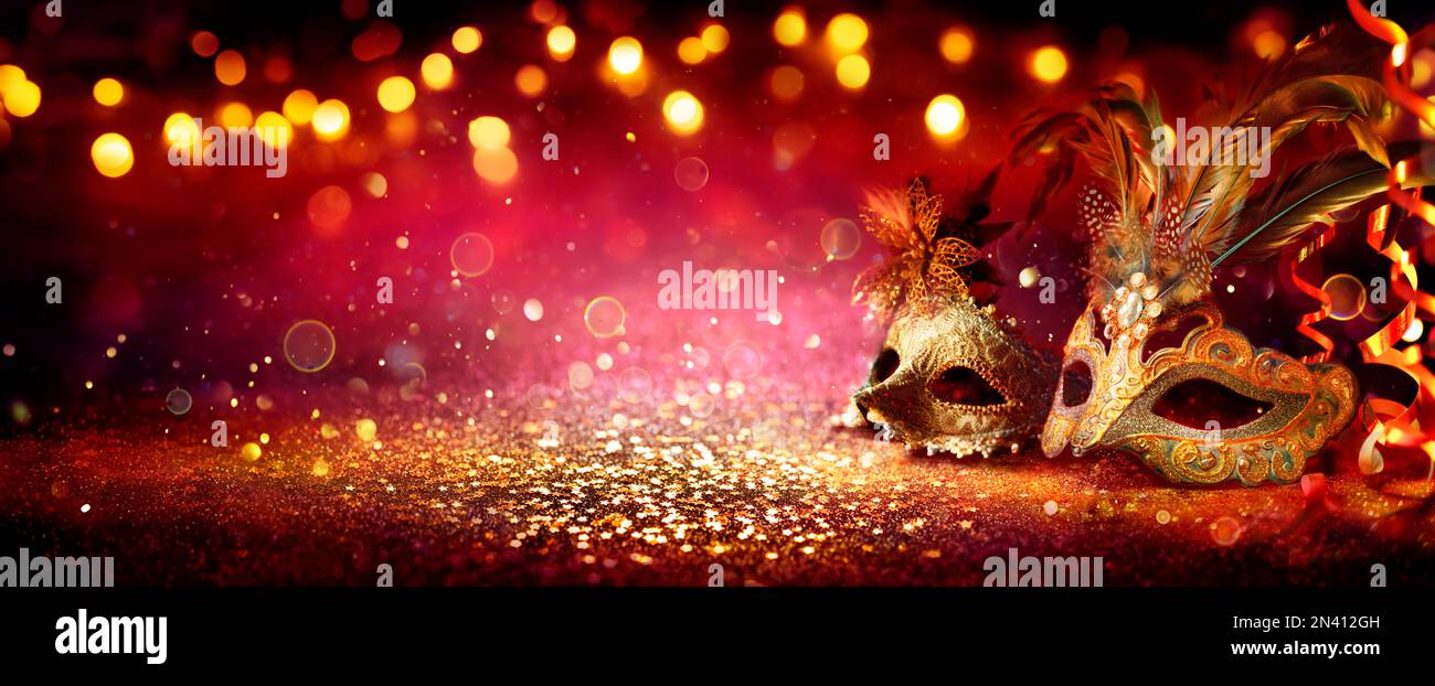 Karnevalsparty - Venezianische Masken Auf Rotem Glitzer Mit Glänzenden Straffern Auf Abstrakten, Unscharfen Bokeh-Lichtern Stockfoto