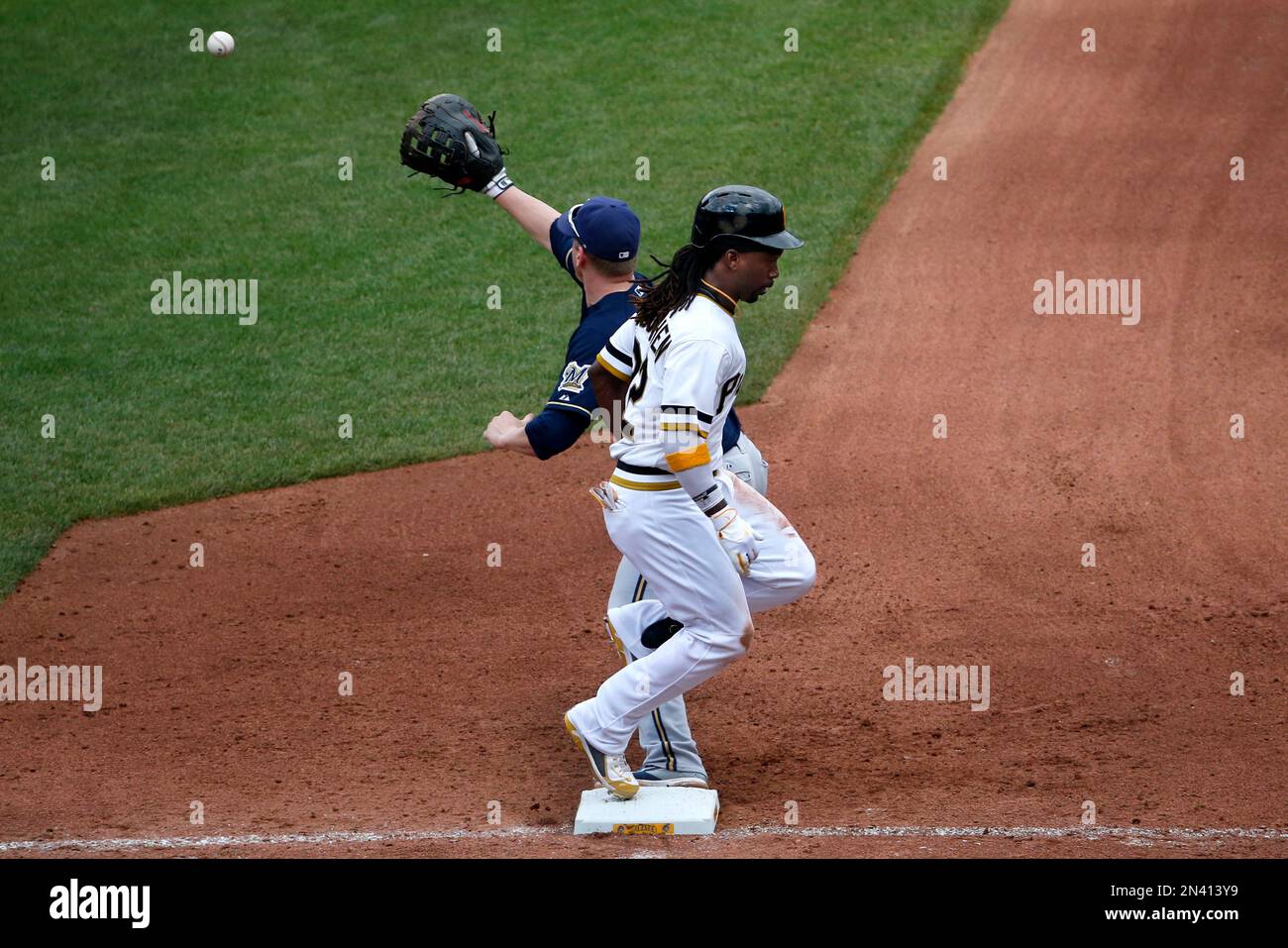 Pittsburgh Pirates' Andrew McCutchen, front, beats out a ground ball to Milwaukee Brewers third baseman Aramis Ramirez (not shown) as Brewers' Lyle Overbay waits for the throw during the seventh inning of a baseball game in Pittsburgh, Sunday, Sept. 21, 2014. McCutchen went on to score the game's only run on a single by Pirates' Russell Martin. The Pirates won 1-0. (AP Photo/Gene J. Puskar) Stockfoto
