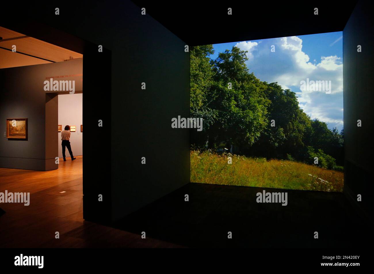 A video image of a landscape is projected as people wander around an exhibition entitled: 'Constable: The Making of a Master ' with works by British landscape painter John Constable, during a preview at the Victoria and Albert Museum, in London, Wednesday, Sept. 17, 2014. Best-known to many for ‘The Hay Wain’ - an artwork which adorns countless decorative plates and trays, the exhibition explores Constable’s influences and takes a look at the creative process behind some of his most famous works. The exhibition will run from Sept. 20, 2014 to Jan. 11. 2015.(AP Photo/Lefteris Pitarakis) Stockfoto