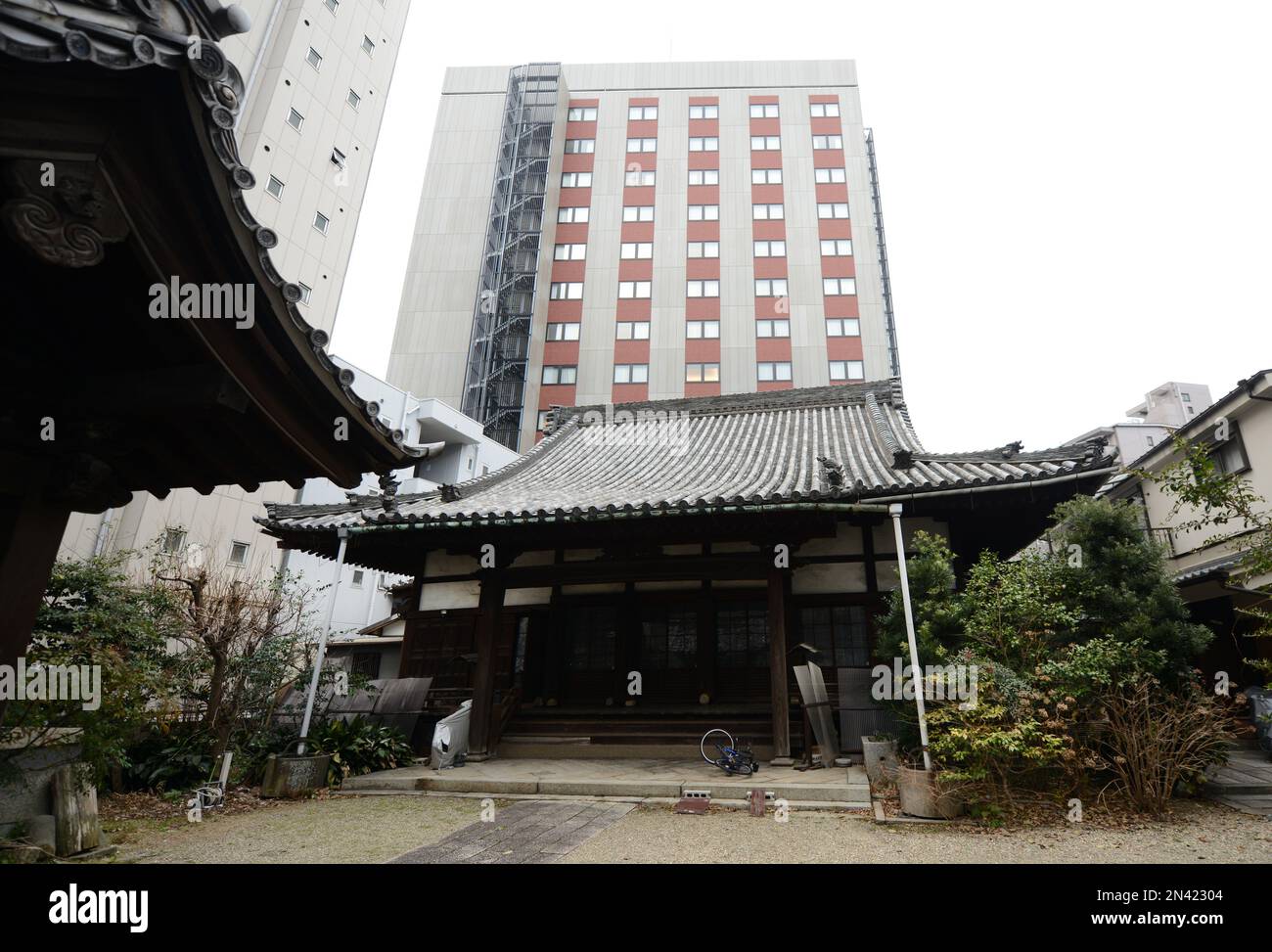 Moderne neue Gebäude, die sich über traditionellen japanischen Häusern erheben. Nagoya, Japan. Stockfoto