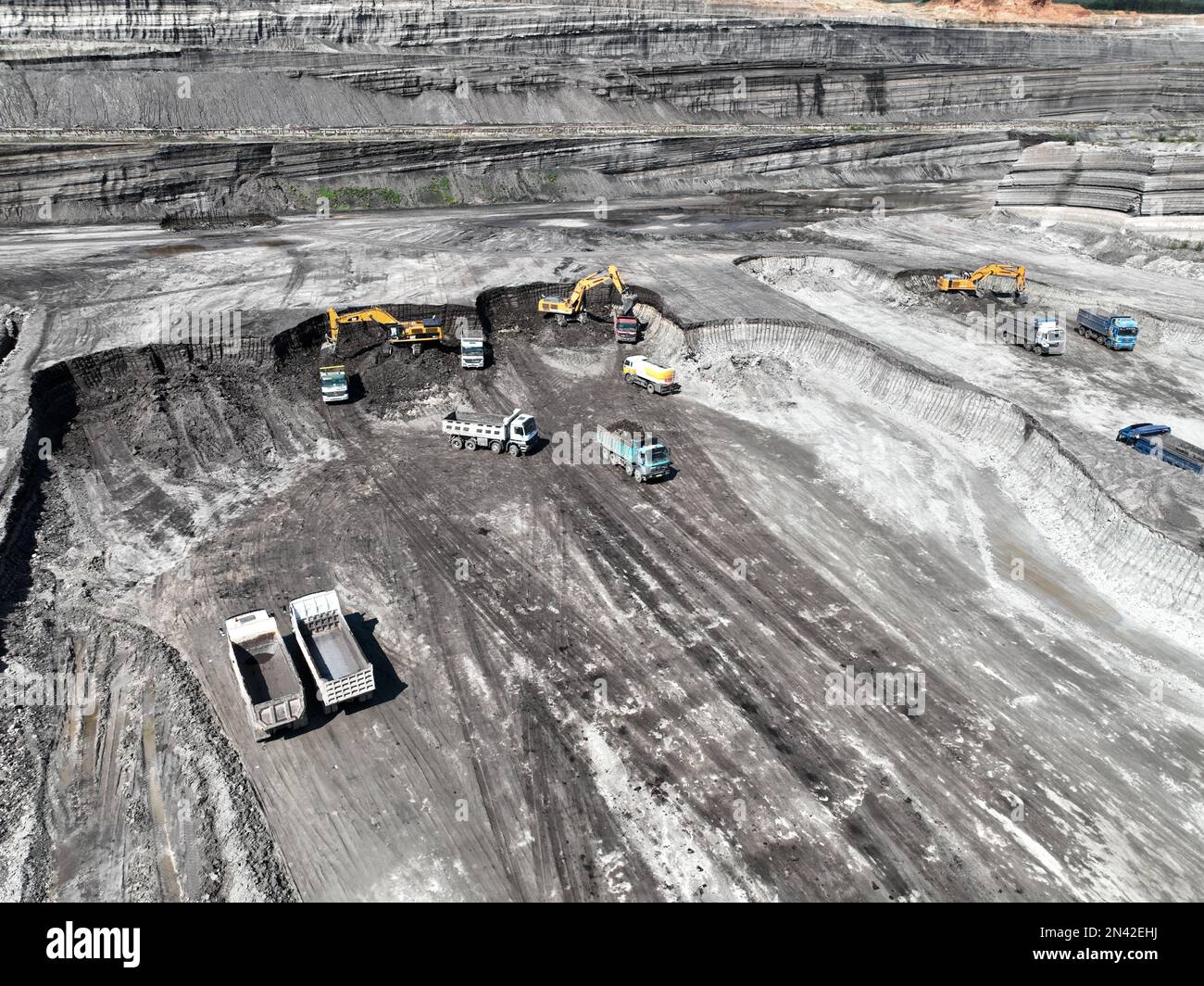 Bagger in Betrieb. Lade Lastwagen auf eine riesige Bergbaustelle. Stockfoto