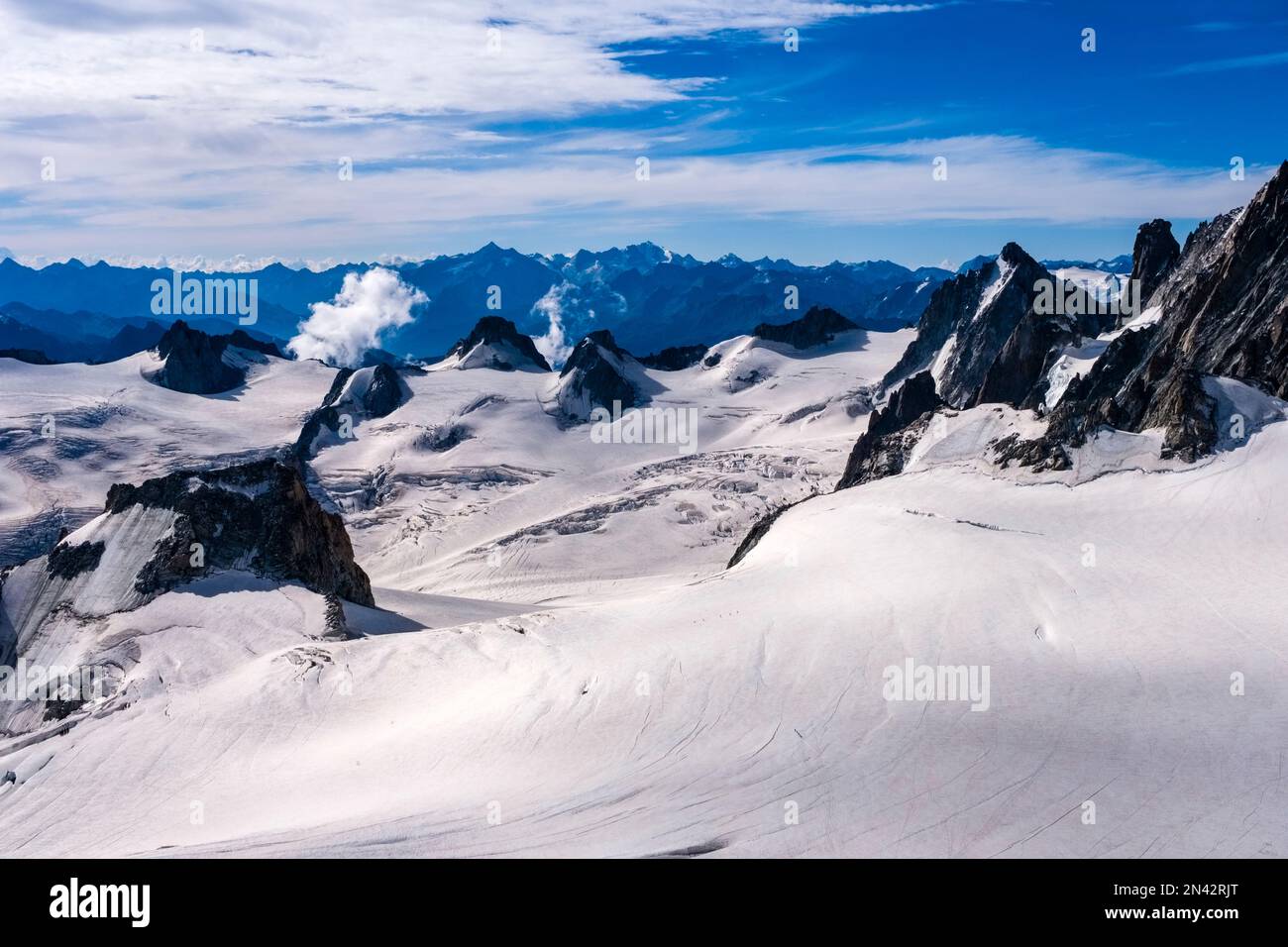 Blick von Aiguille du Midi auf den Géant-Gletscher und die Gipfel südlich des Mont Blanc-Massivs, mit Grand Paradiso in der Ferne. Stockfoto