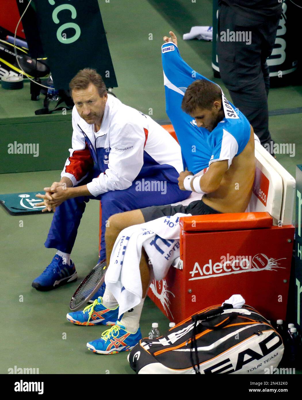 Slovakia Davis Cup captain Miloslav Mecir, left, talks to Martin Klizan, as Klizan changes his shirt between games during the first set of a Davis Cup tennis match against Sam Querrey, of the United States, Friday, Sept. 12, 2014, in Hoffman Estates, Ill. (AP Photo/Charles Rex Arbogast) Stockfoto