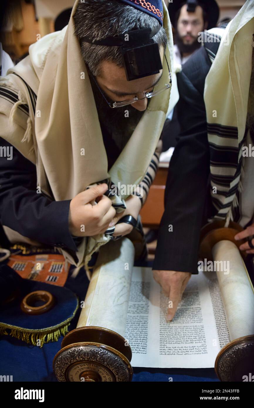 Ein orthodoxer jüdischer Mann wird zur Torah gerufen und vor seinem Segen wird der Anfang des Teils gezeigt, der gelesen werden soll. In Crown Heights, Brooklyn. Stockfoto