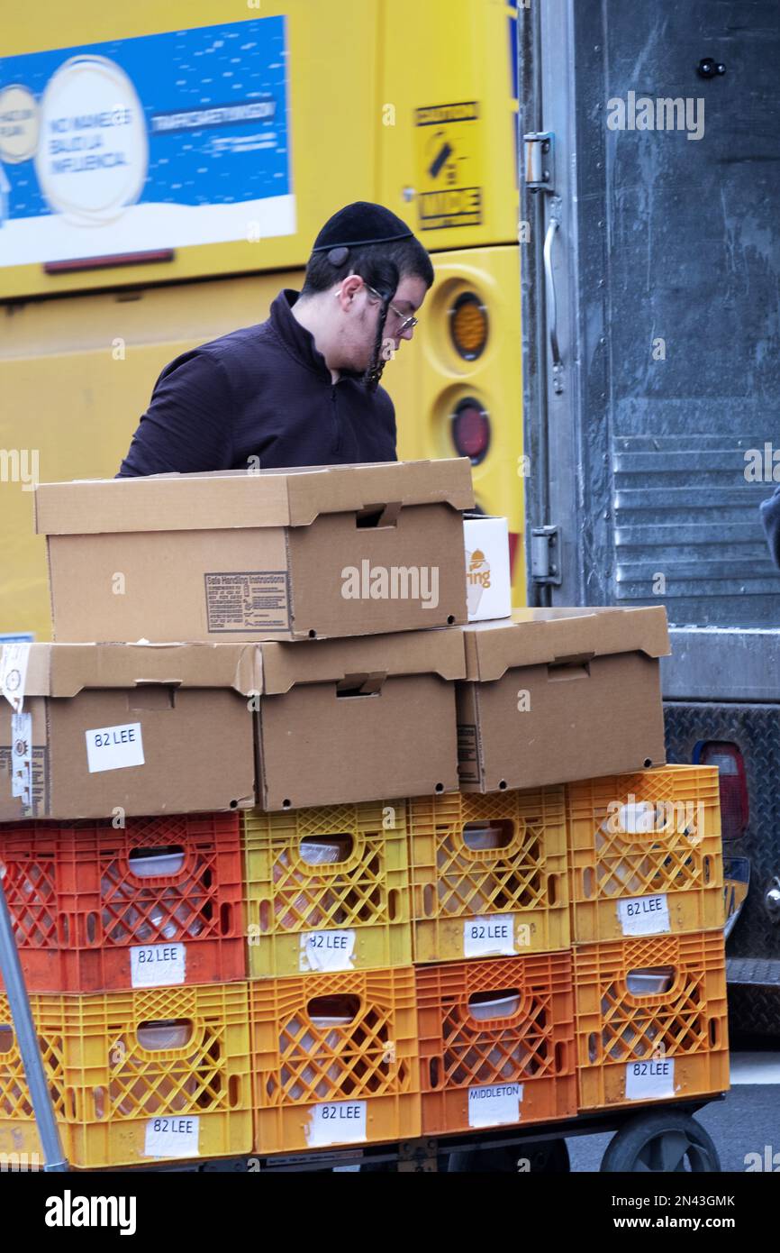 Ein Arbeiter für Satmar Meat liefert Kisten und Kartons vom Lager zu einem der Geschäfte. In Brooklyn, New York. Stockfoto