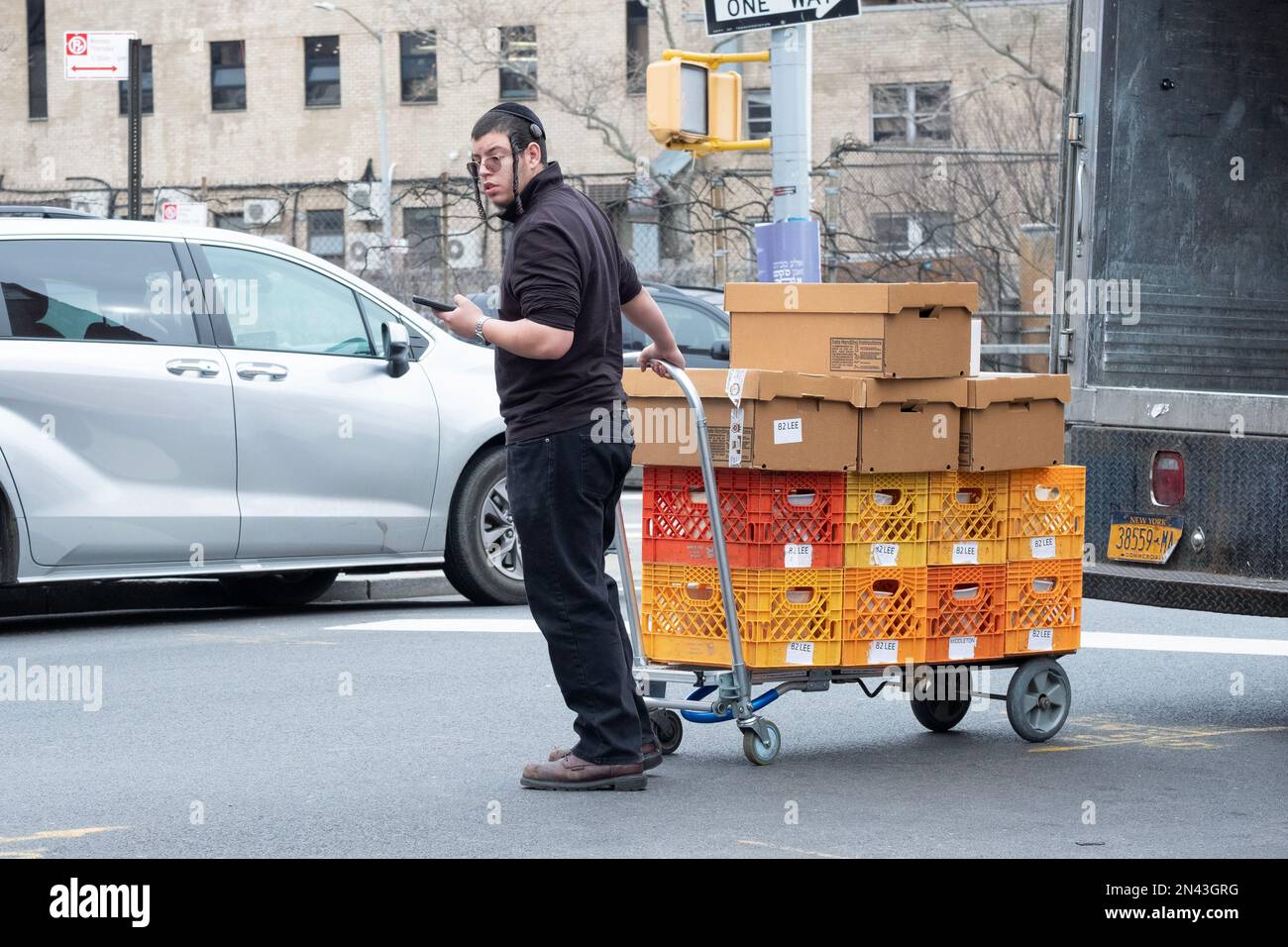 Ein Arbeiter für Satmar Meat liefert Kisten und Kartons vom Lager zu einem der Geschäfte. In Brooklyn, New York. Stockfoto