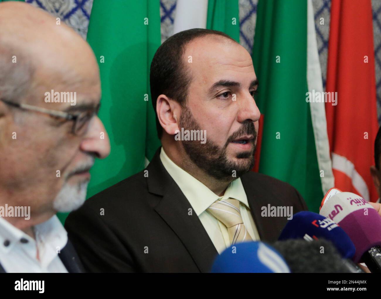 Nasr al-Hariri, secretary-general of the Syrian National Coalition, Syria's main opposition group, speaks during a press conference following his meeting with the Arab League's Secretary-General Nabil Elaraby at the League's headquarters in Cairo, Egypt, Saturday, Sept. 6, 2014. Haitham al-Maleh, a senior member of the coalition, stands at left. (AP Photo/Amr Nabil) Stockfoto