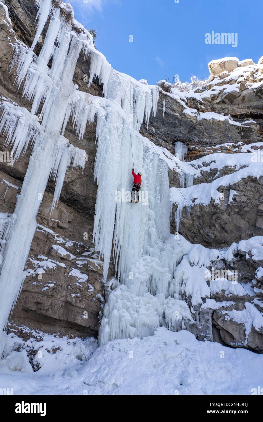 Ein Eiskletterer auf einem natürlichen gefrorenen Wasserfall im Price Canyon in Utah. Stockfoto