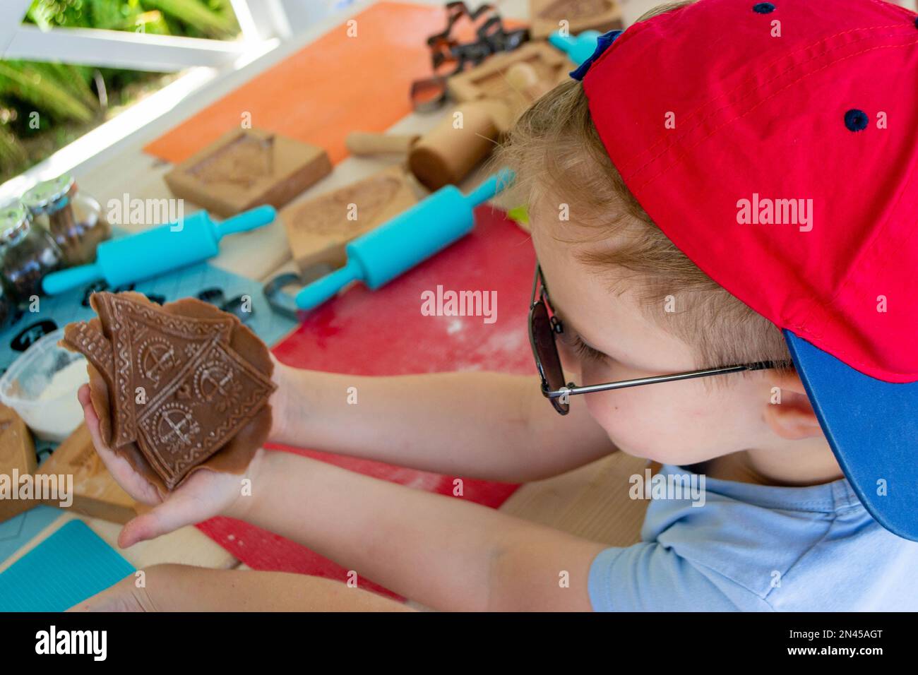 Walznadel und Mehl-Lebkuchen. Bäcker sprühen Eiweiß von Hand auf Lebkuchen. Hochwertiges Foto Stockfoto