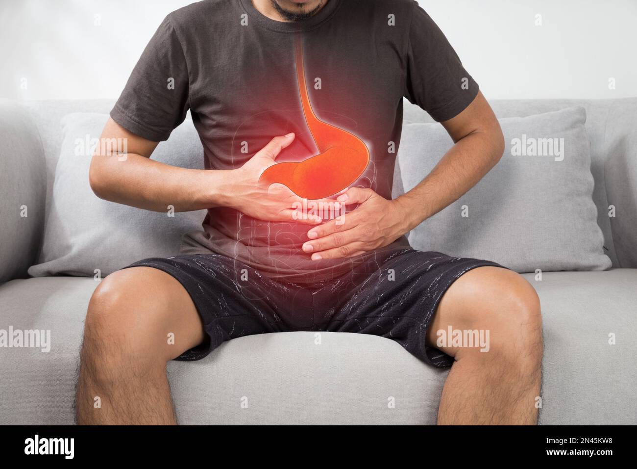 Saures Reflux oder Sodbrennen, das Foto des Magens ist auf dem Männerkörper vor grauem Hintergrund, schlechte Gesundheit, männliche Anatomie Konzept Stockfoto