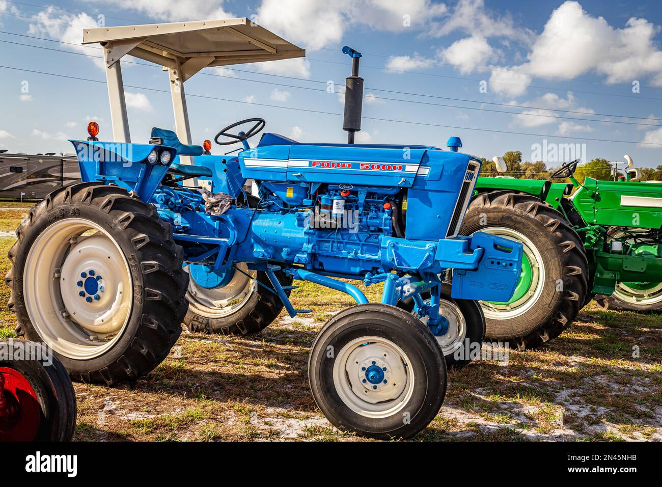 Fort Meade, Florida - 22. Februar 2022: Schmale Seitenansicht eines 1968 Ford 5000 Reihen Ernteguttraktors auf einer lokalen Traktormesse. Stockfoto