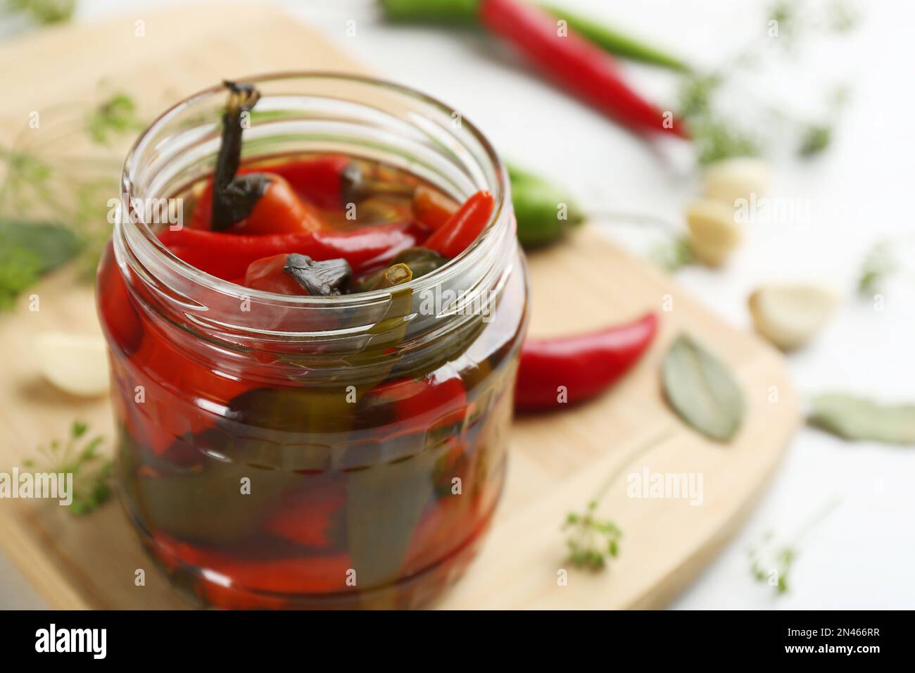Glas mit eingelegtem Chili auf dem Tisch, Nahaufnahme. Platz für Text Stockfoto