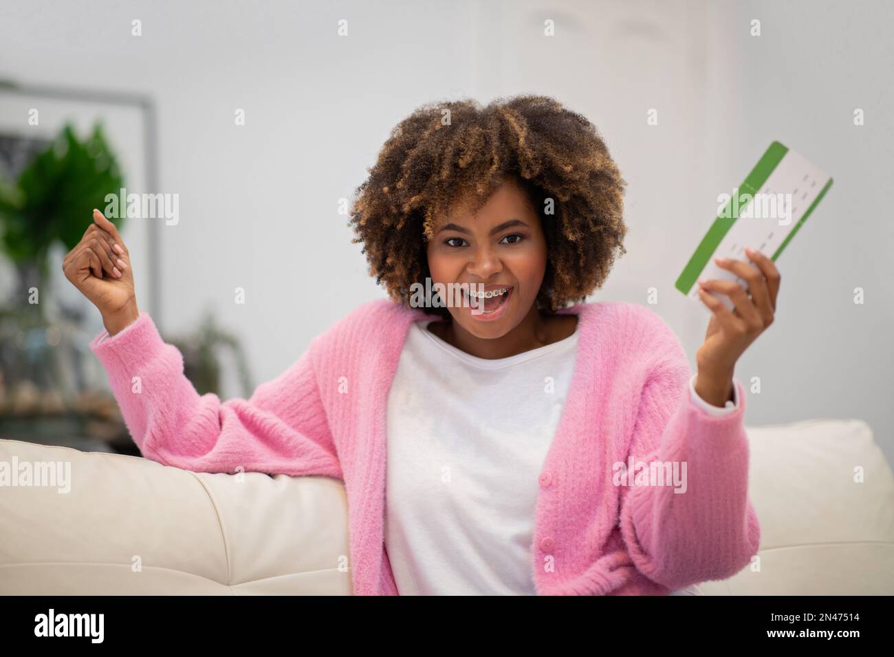 Emotionale schwarze Frau mit Flugticket und Gesten Stockfoto
