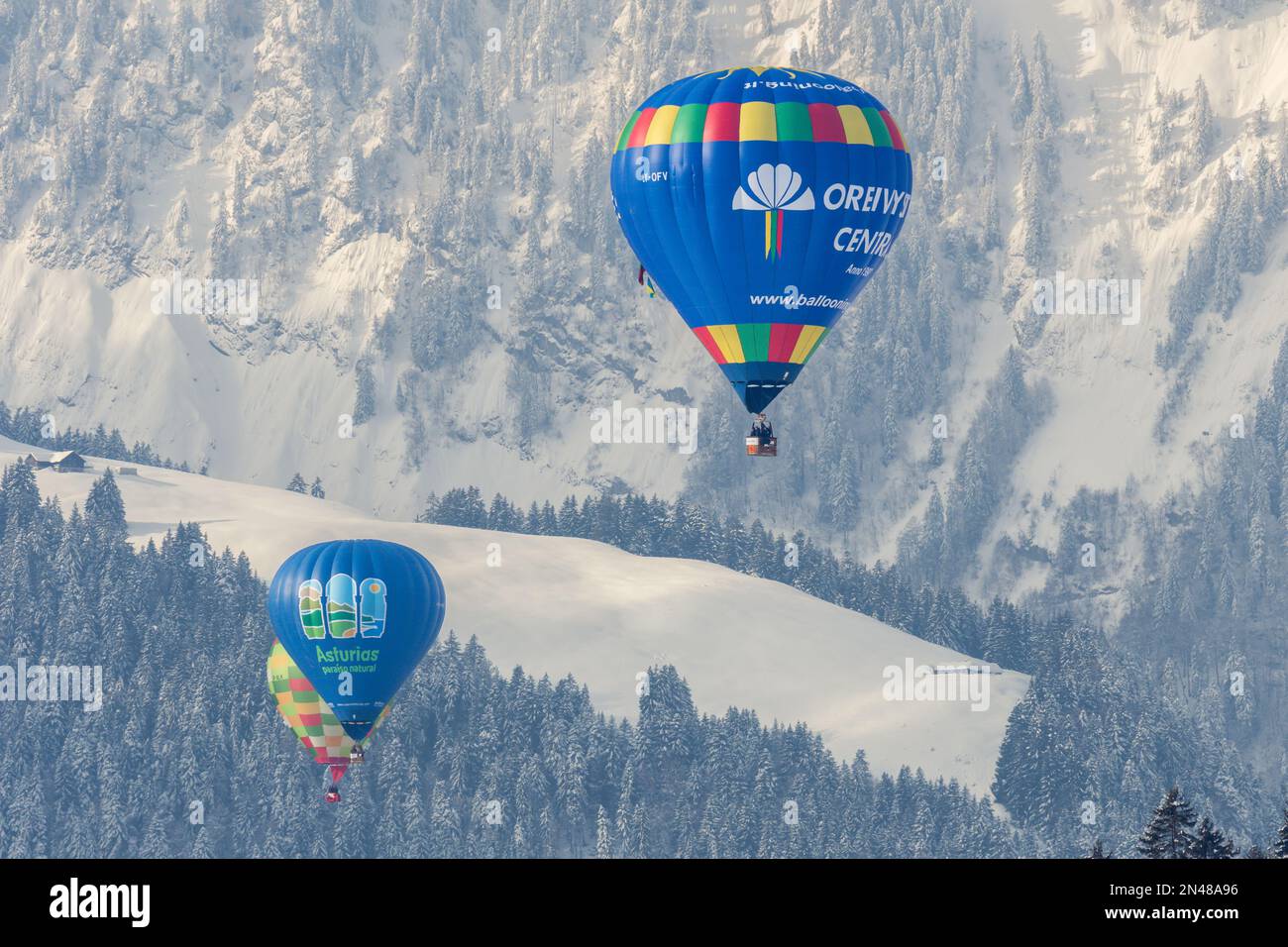 Chateau-d'Oex, Vaud, Schweiz - 23. Januar 2023: Heißluftballon im Flug. Oreivystes centras Heißluftballonfahrt gegen den Wald in Switzerla Stockfoto