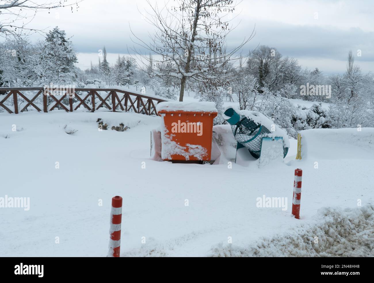 Mülltonnen im Stadtpark mit Schnee bedeckt. Stockfoto