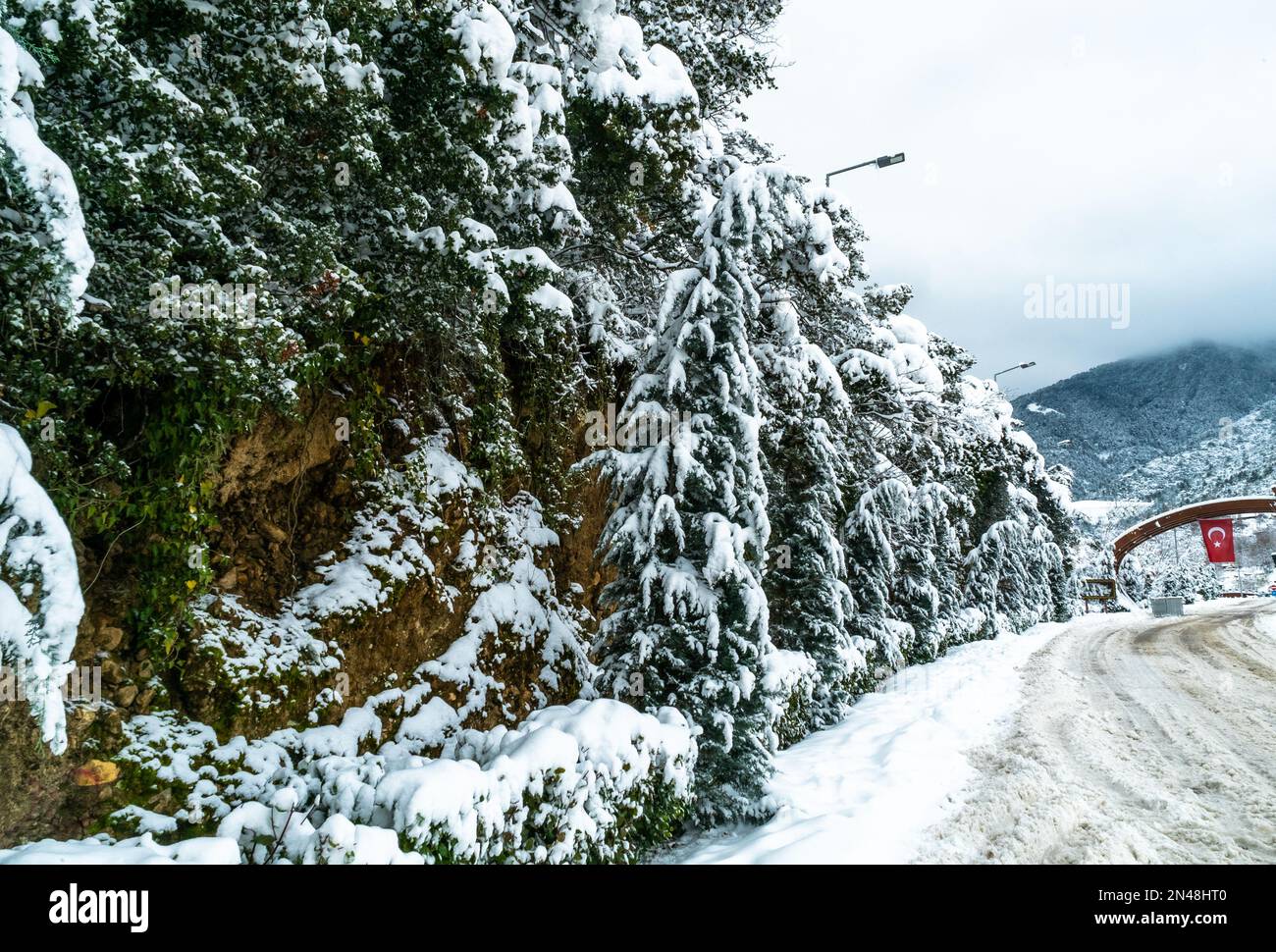 Eintritt zum Nationalpark mit türkischer Flagge im Winter sind die Straßen gefroren. Nach dem Schneesturm ist der Berg mit Schnee bedeckt. Stockfoto