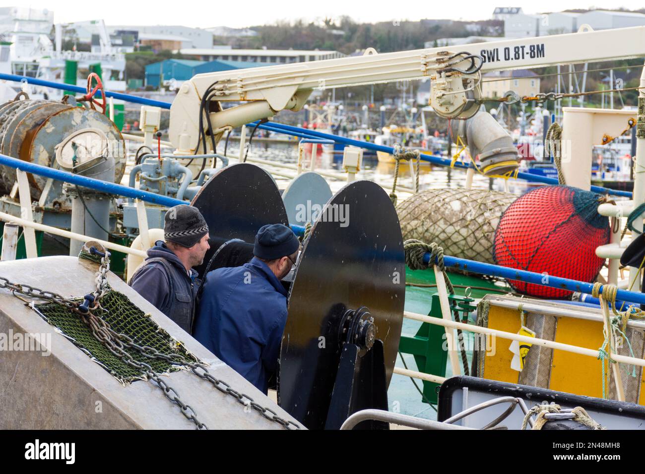 Killybegs Fischereihafen, Männer arbeiten an Winden auf einem Trawler, der in der Grafschaft Donegal, Irland, festgemacht ist Stockfoto