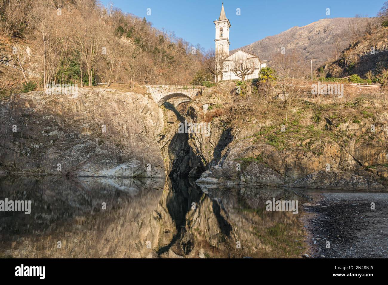 Die wunderschöne Schlucht von Sant'Anna mit der Kirche, die sich im Wasser des Flusses spiegelt Stockfoto