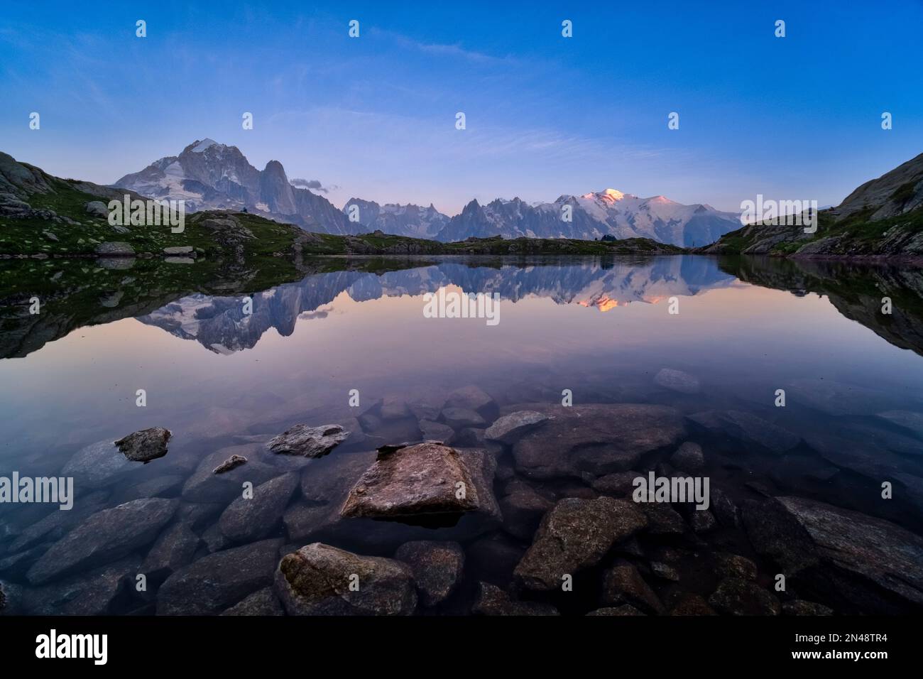 Die Gipfel des Mont Blanc-Massivs spiegeln sich bei Sonnenuntergang in den Lacs des Chéserys wider, der Gipfel des Mont Blanc fängt die letzte Sonne des Tages ein. Stockfoto