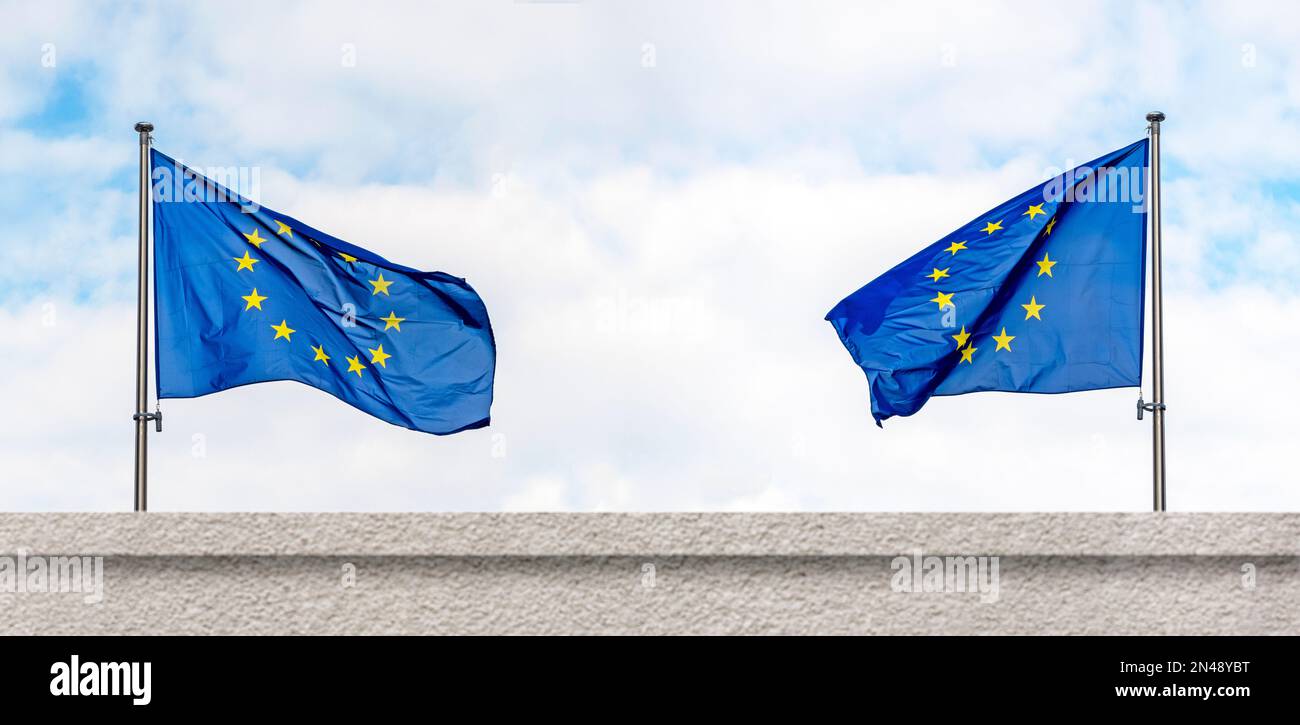 Zwei Flaggen der Europäischen Union oder EU-Flagge neben der Mauer, Konzeptbild Stockfoto