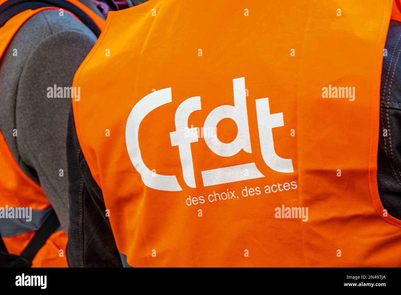 Logo der französischen Gewerkschaftsorganisation CFDT (Französischer Demokratischer Gewerkschaftsbund) auf einer orangefarbenen Weste, die während einer Demonstration fotografiert wurde Stockfoto