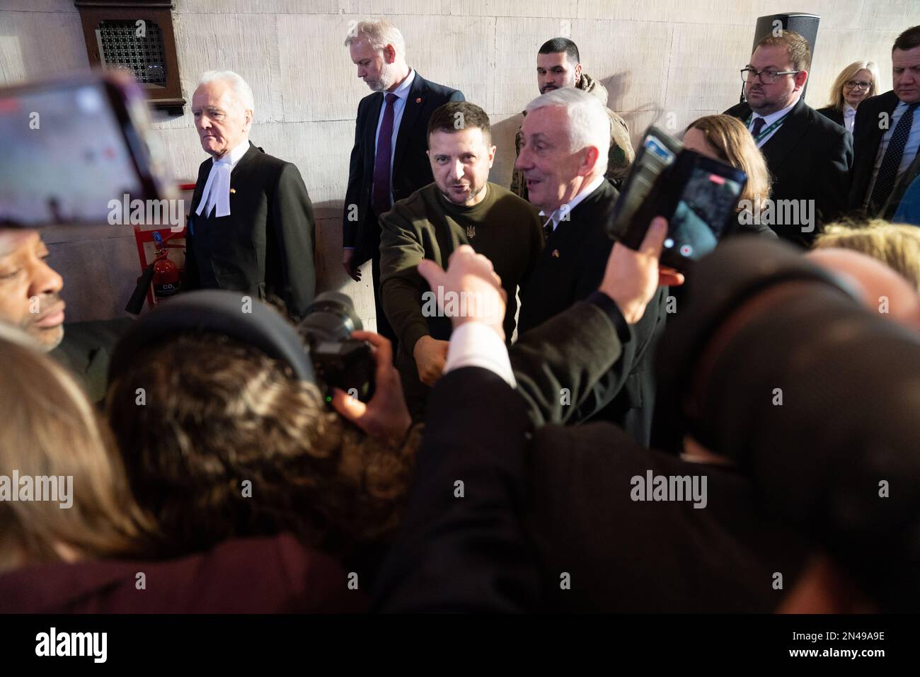 Der ukrainische Präsident Wolodymyr Zelensky schüttelt den Abgeordneten die Hand, während er mit dem Sprecher des Unterhauses Sir Lindsay Hoyle und dem Sprecher des Oberhauses Lord McFall durch den Palast von Westminster in London geht. Bilddatum: Mittwoch, 8. Februar 2023. Stockfoto