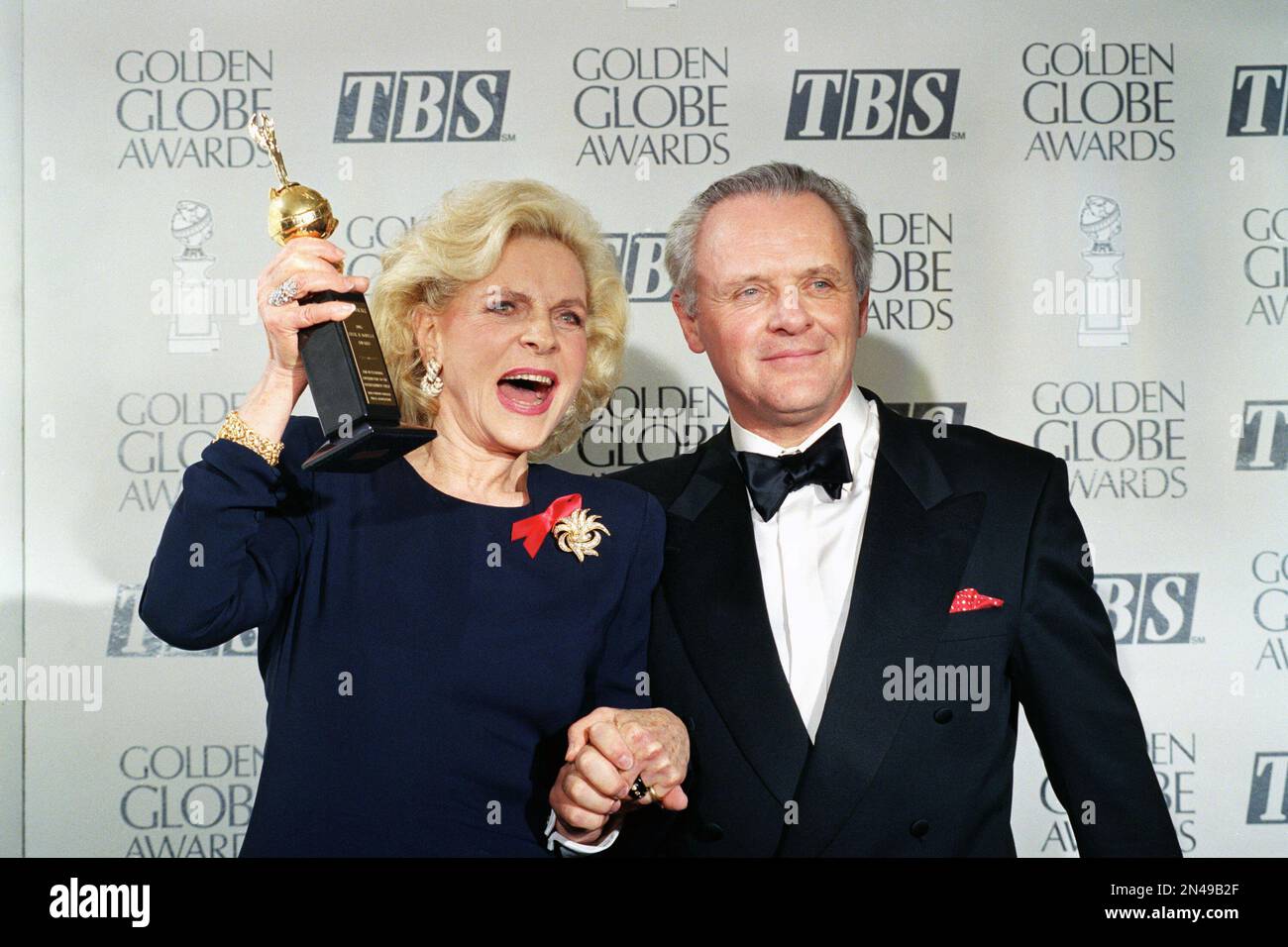 FILE - This Jan. 23, 1993 file photo shows actress Lauren Bacall holding up her Cecil B. DeMille Award for Lifetime Achievement as she holds hands with actor Anthony Hopkins backstage at the 50th annual Golden Globe Awards in Beverly Hills, Calif. Bacall, the sultry-voiced actress and Humphrey Bogart’s partner off and on the screen, died Tuesday, Aug. 12, 2014 in New York. She was 89. (AP Photo/Reed Saxon, File) Stockfoto