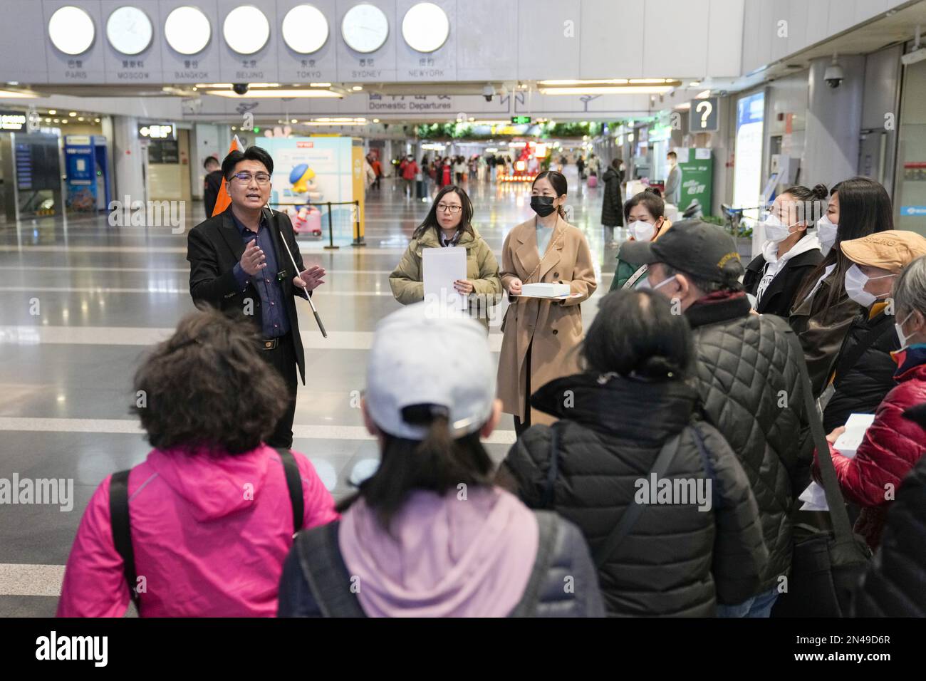 Peking, China. 8. Februar 2023. Ein Reiseleiter erklärt die Reisevorbereitungen für Touristen, die nach Thailand reisen, am Beijing Capital International Airport in Peking, Hauptstadt von China, am 8. Februar 2023. Am Montag nahm China wieder Gruppenreisen in 20 Länder auf, darunter Thailand, die Malediven, die Vereinigten Arabischen Emirate, Russland und Neuseeland. Kredit: Ju Huanzong/Xinhua/Alamy Live News Stockfoto