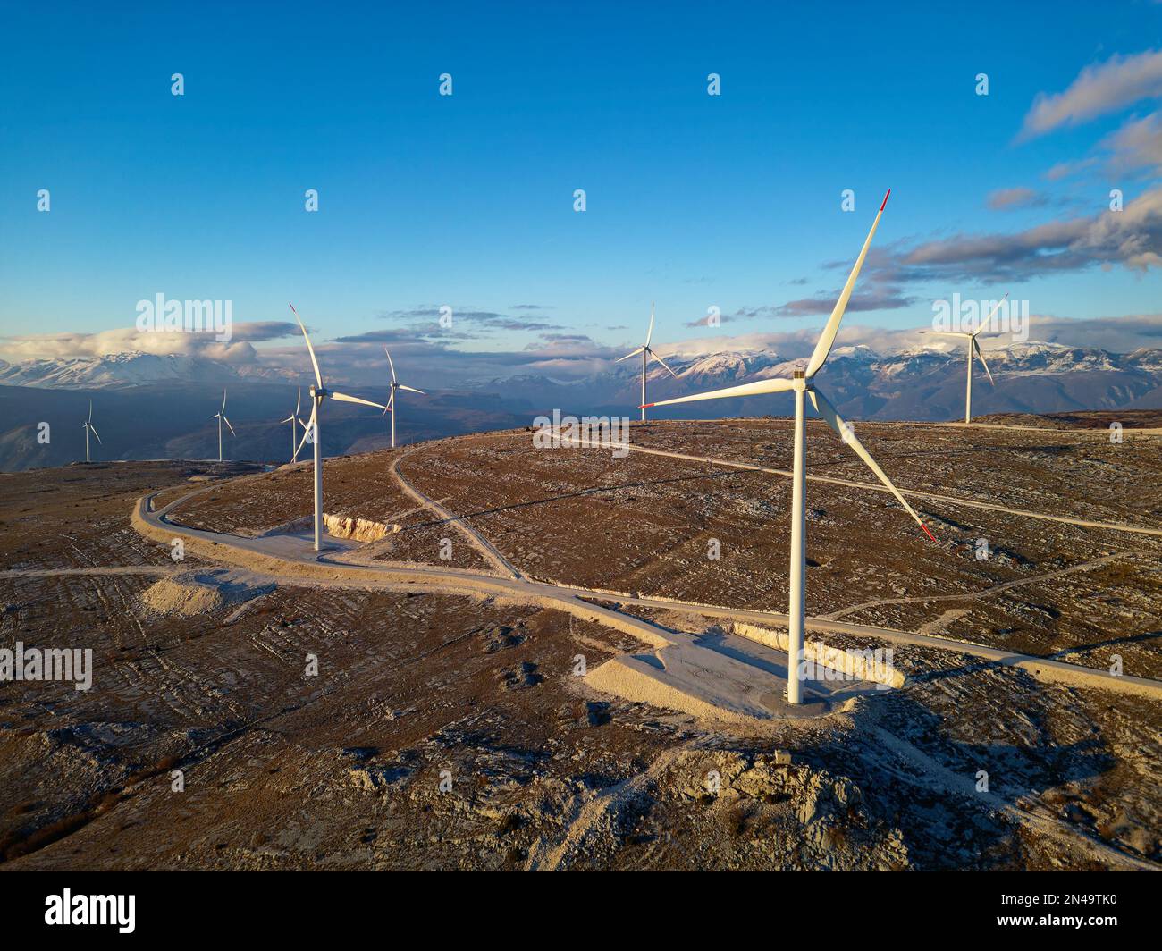 Windmühlen auf den Hügeln bei Sonnenuntergang. Erneuerbare Energien, grüne Energie. Windkraft und umweltfreundlich. Nachhaltige Zukunft. Ende fossiler Brennstoffe. Stockfoto