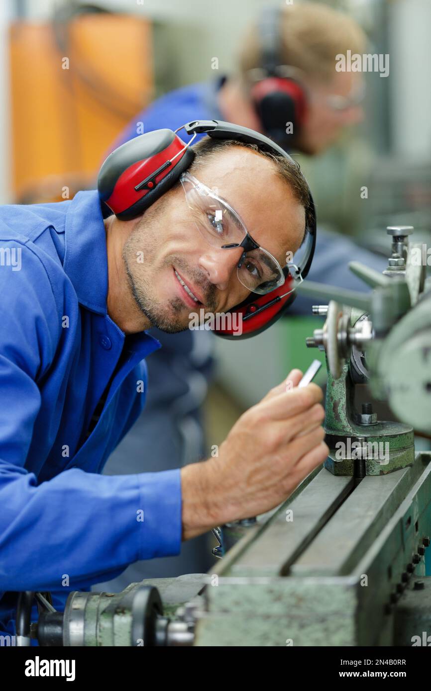 Bild eines männlichen Schlossers mit Schutzbrille und Ohrenschützer Stockfoto