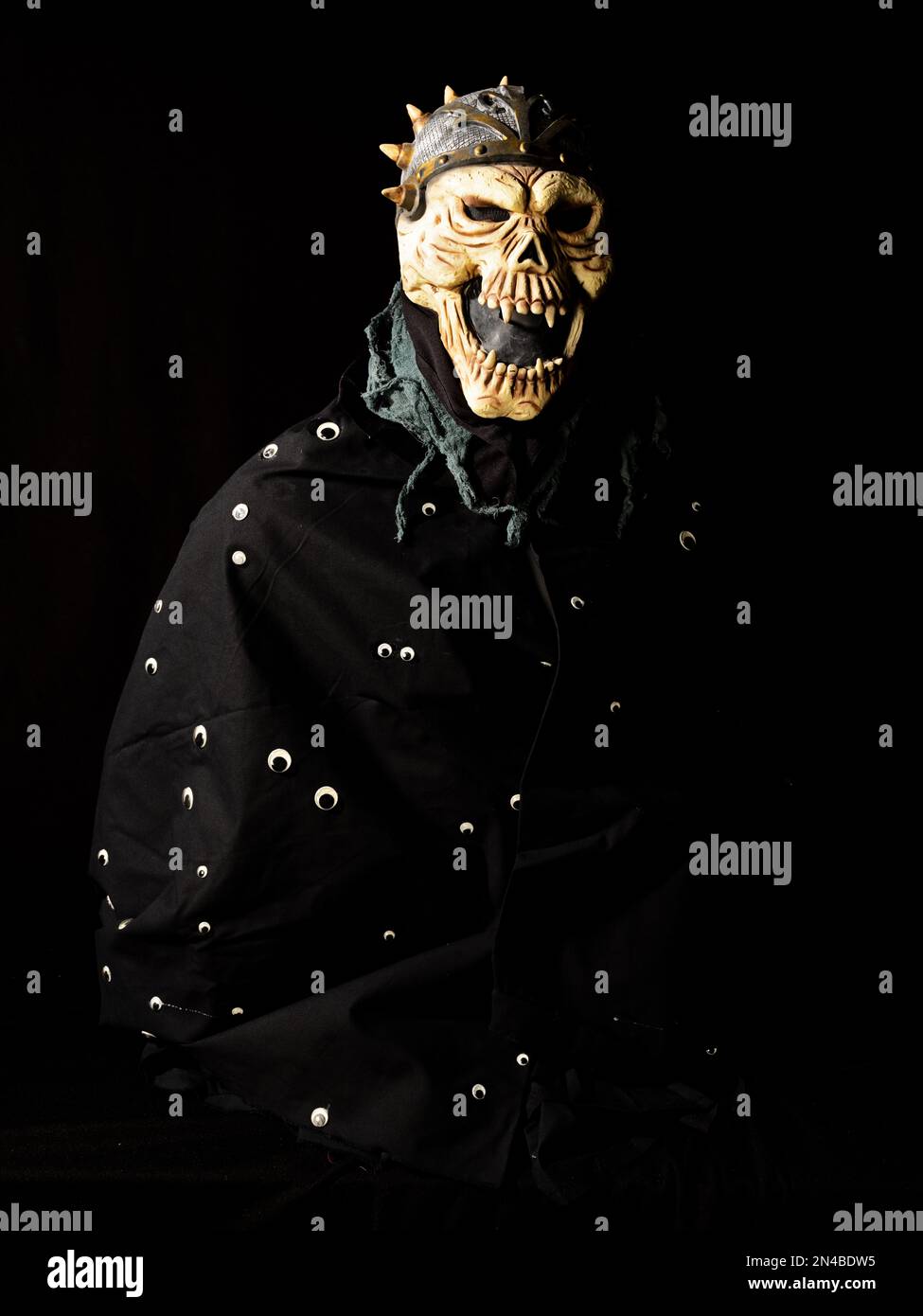 Eine gruselige Ghul-Maske mit einem Umhang voller Googly Eyes für Halloween. Stockfoto