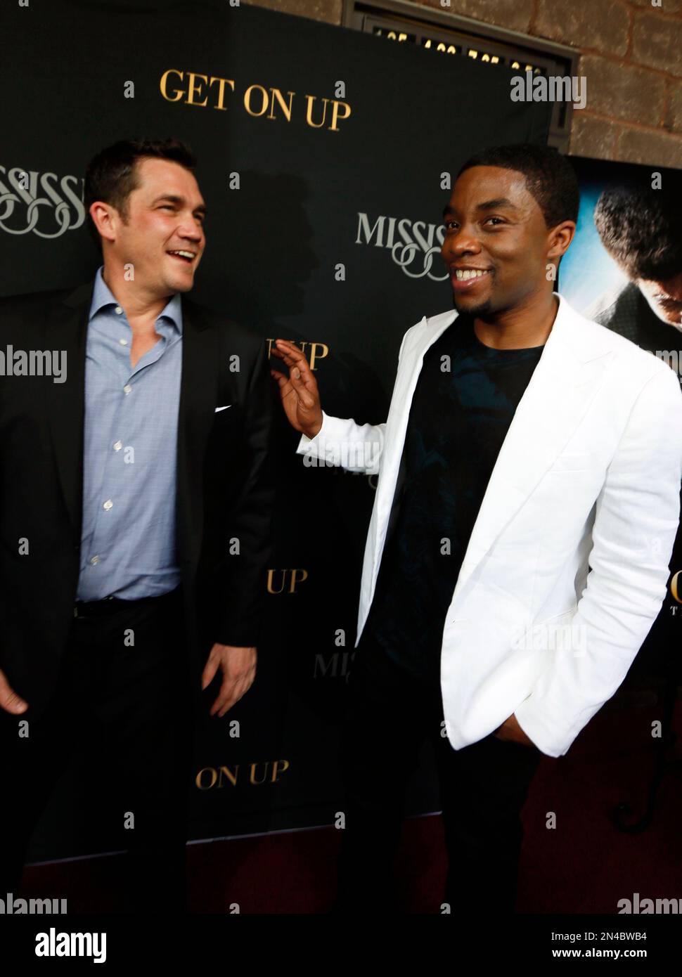 Chadwick Boseman, right, who stars as James Brown in "Get On Up," a movie based on the life story of "the Godfather of Soul," jokes with film director Tate Taylor, in Madison, Miss., prior to a screening of the film, Sunday, July 27, 2014. The film, directed by Mississippi native Taylor, depicts Brown's life from 5-years-old until he was 60. Brown died in 2006 at 73. (AP Photo/Rogelio V. Solis) Stockfoto