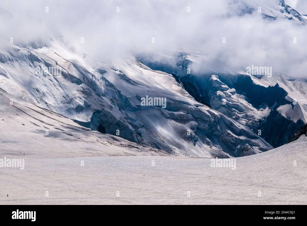 Blick von Aiguille du Midi auf die Pisten, Spalten und Abbrechungen des oberen Teils des Géant-Gletschers, Wolken ziehen heran. Stockfoto