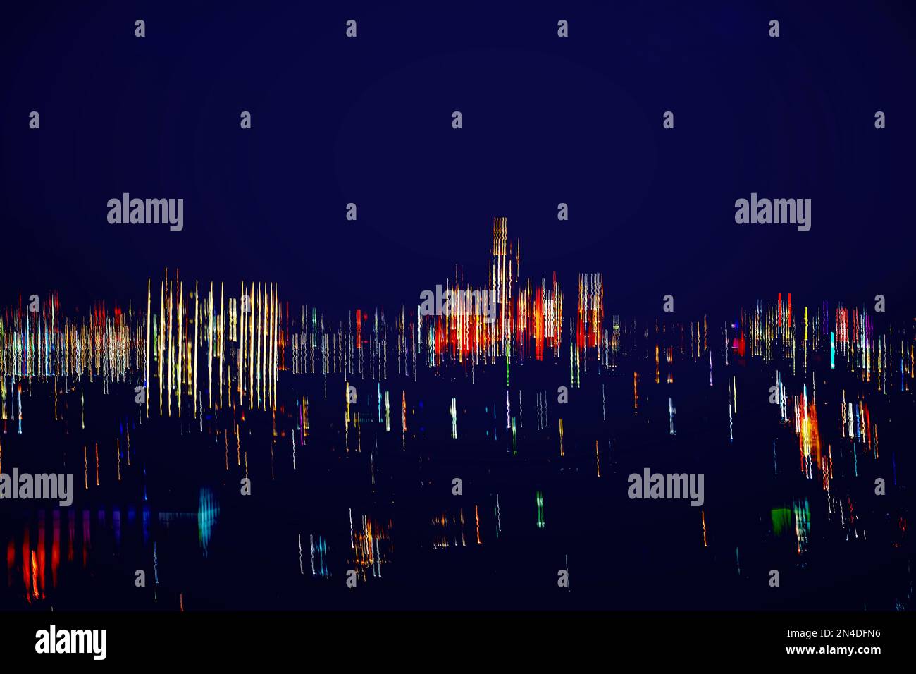 Abstrakte Wolkenkratzer bei Nacht. Moderne Neonstadt, malerisches helles Bokeh, verschwommener Fokus, moderner Hintergrund Stockfoto