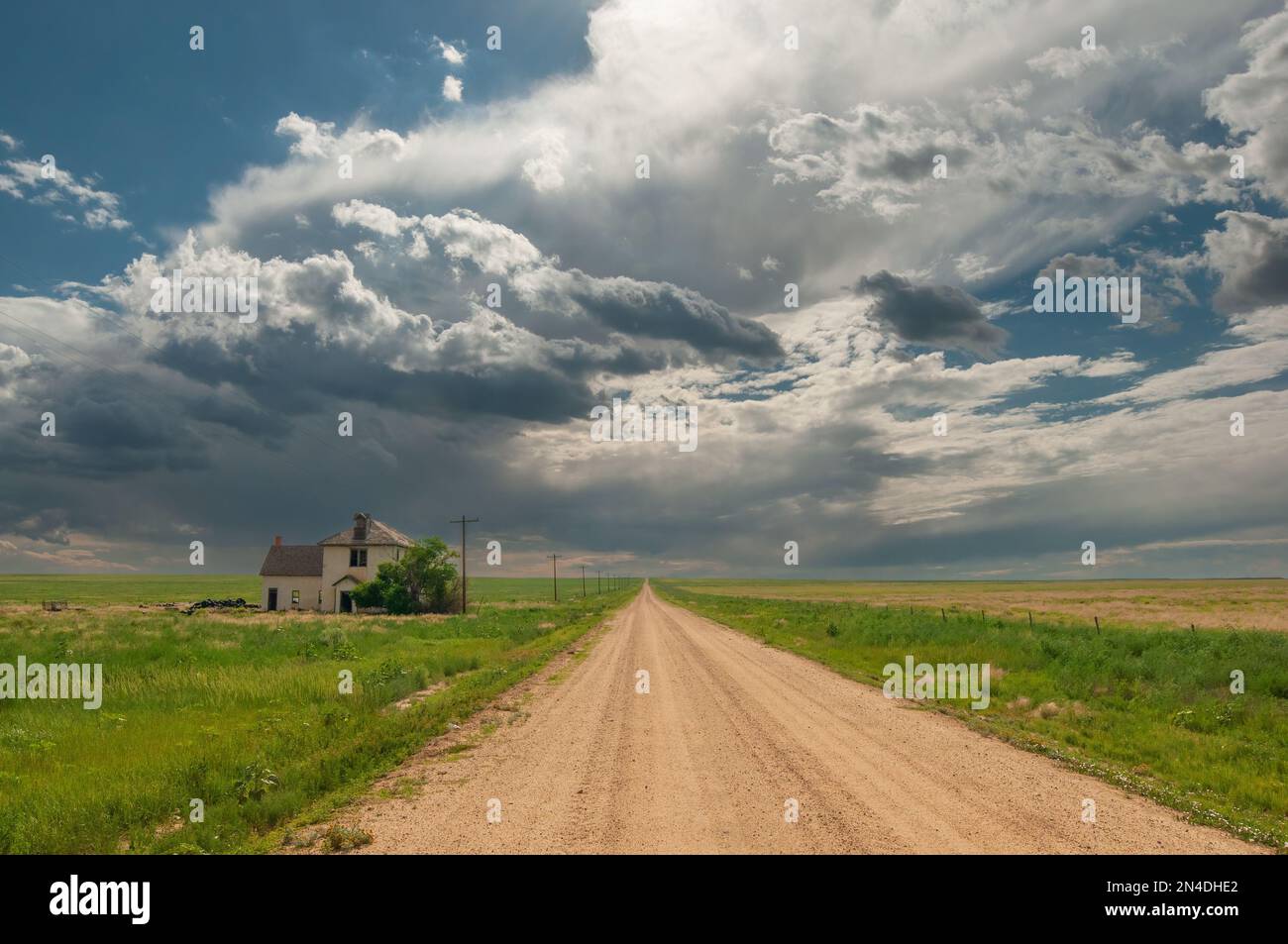 Stürmischer Himmel über einer Landstraße und ein verlassenes Haus scheinen die Sommermonsunsaison einzuläuten. Stockfoto