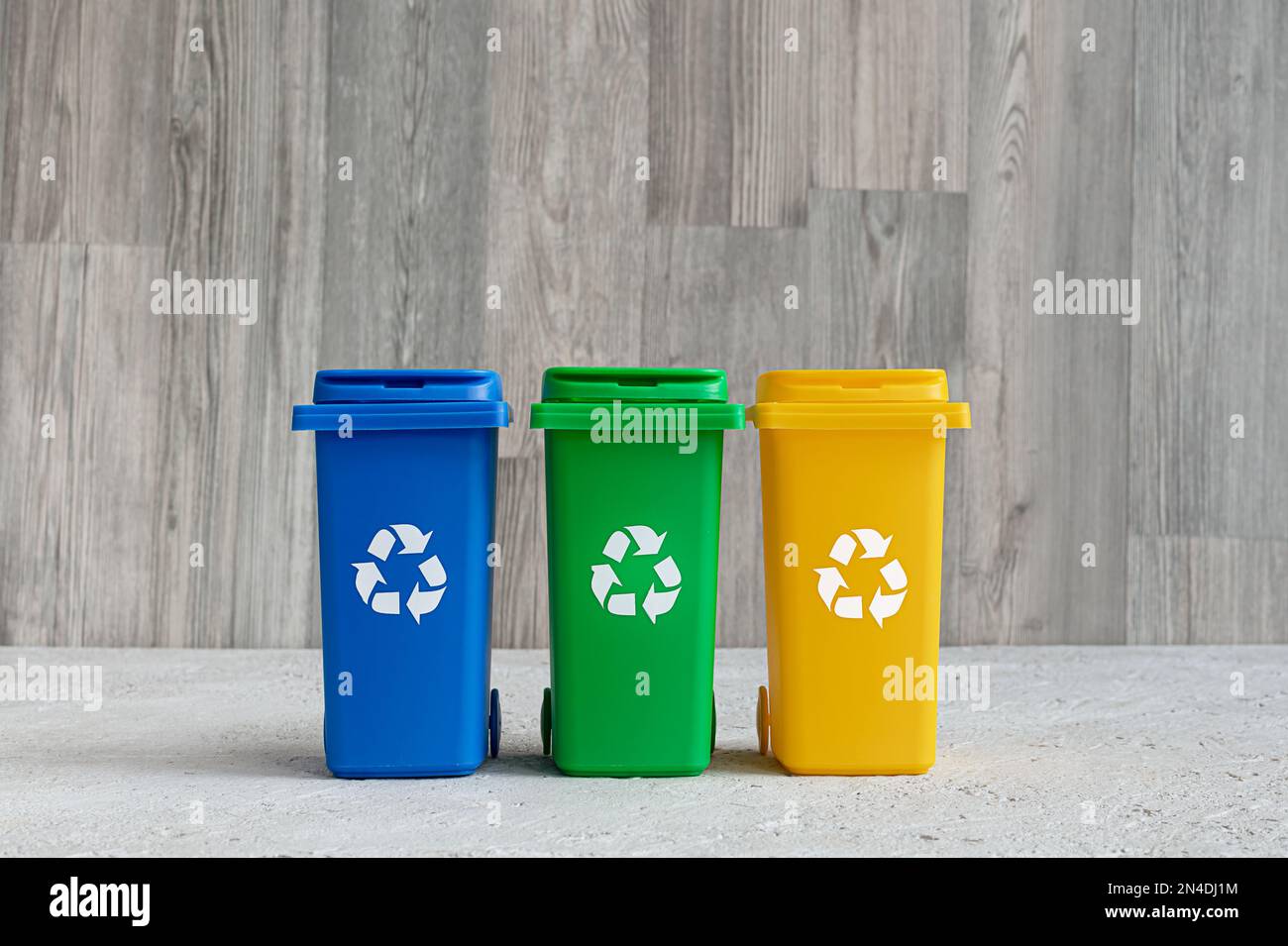 Blauer, grüner und gelber Behälter für getrennte Müllsammlung, Abfallrecyclingkonzept Stockfoto