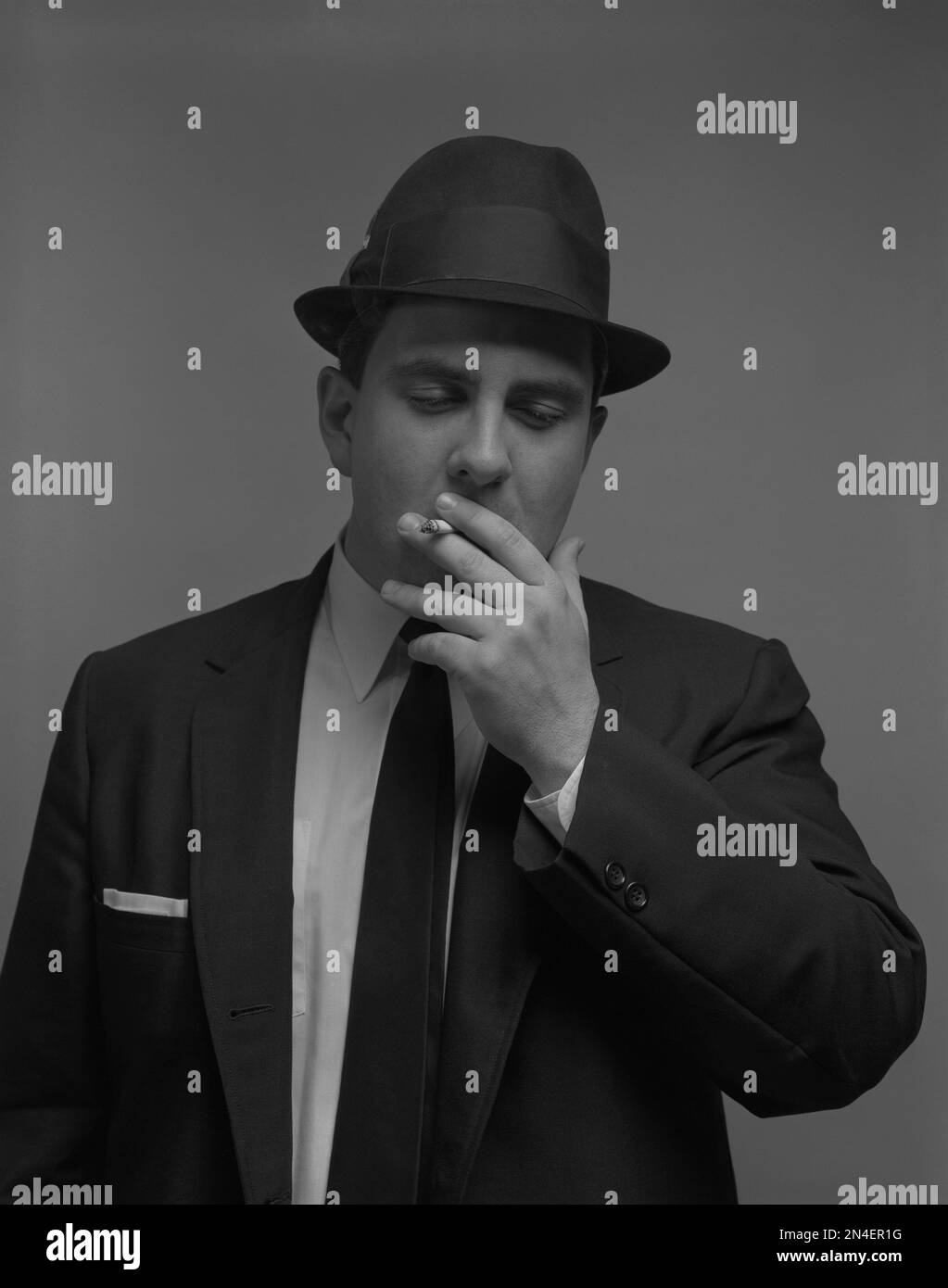 Halblängenporträt eines Geschäftsmannes, der eine Zigarette raucht Stockfoto